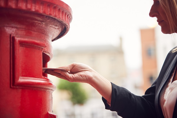 close up of businesswoman posting letter into city YJZMLC7